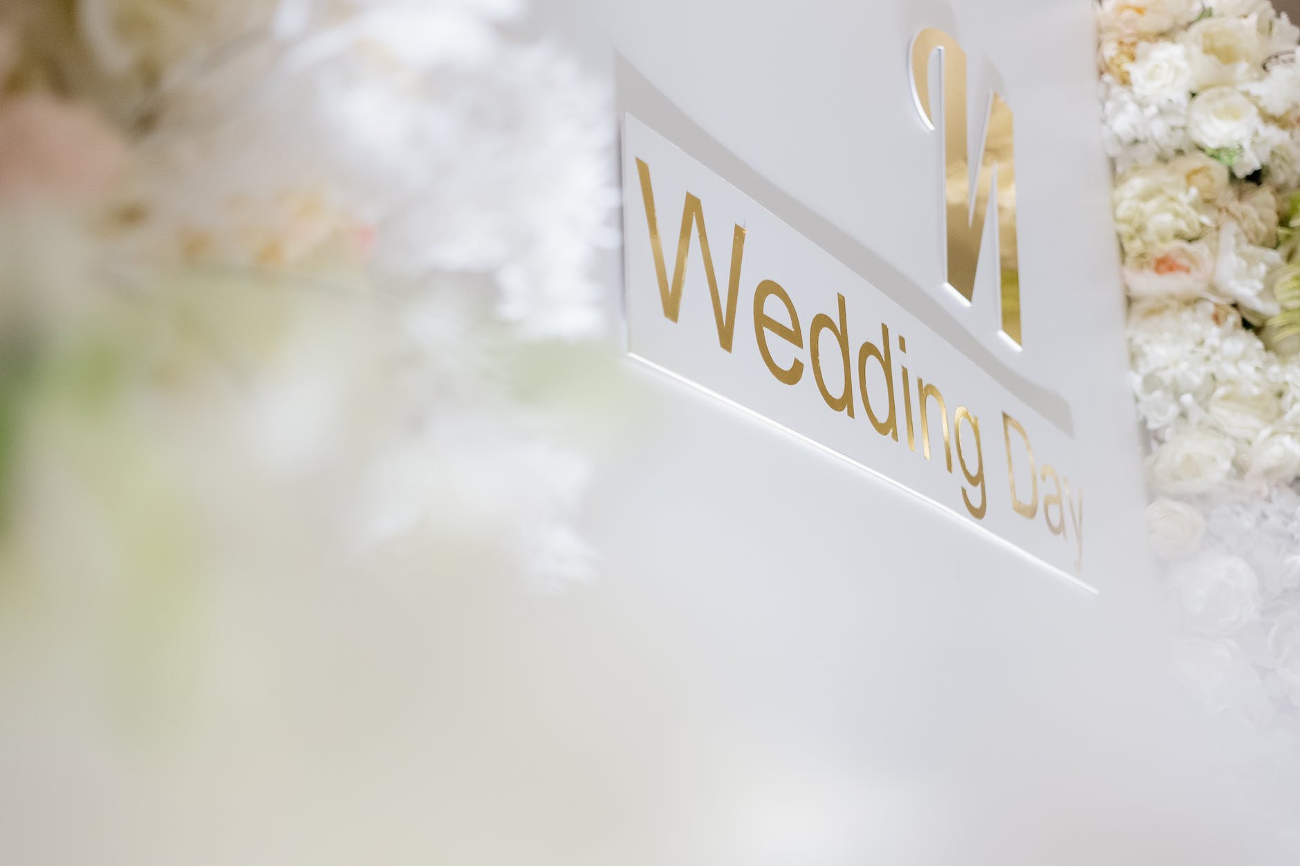 a white wedding day sign beside flowers