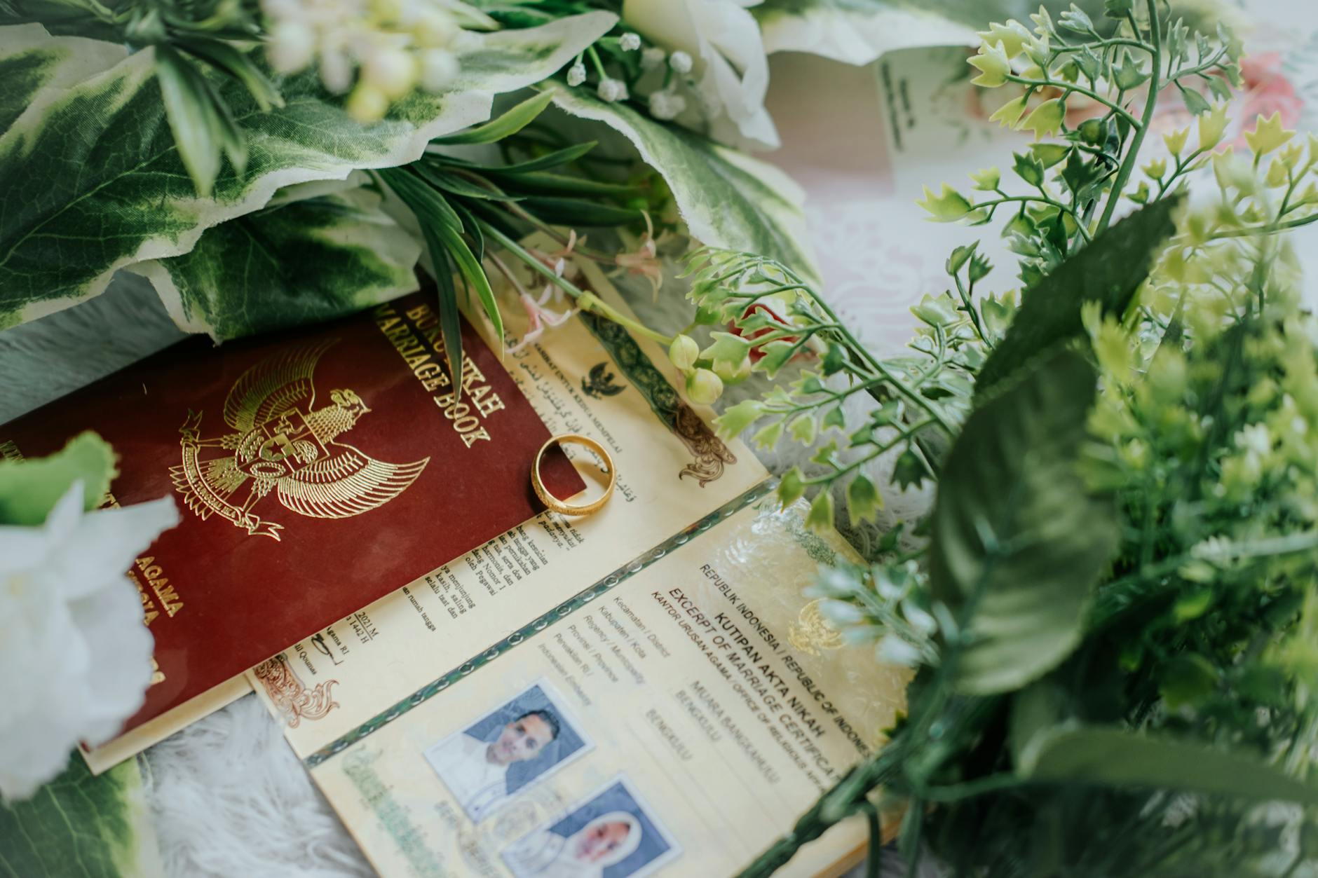 documents and a wedding ring with a bouquet